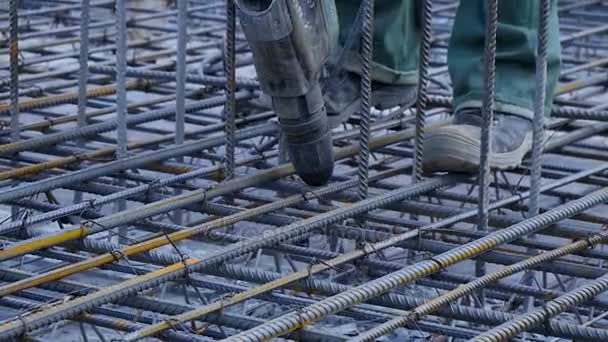 Trabajador de construcción. Trabajador en el sitio de construcción haciendo marco de metal de refuerzo para el vertido de hormigón — Vídeos de Stock