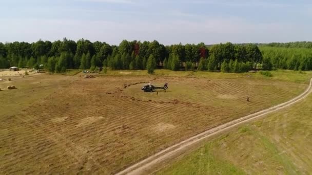 Helikopter tiba di lapangan hijau. Helikopter mendarat di rumput kuning, hari berawan. Terbang dengung dan ladang gandum hijau — Stok Video
