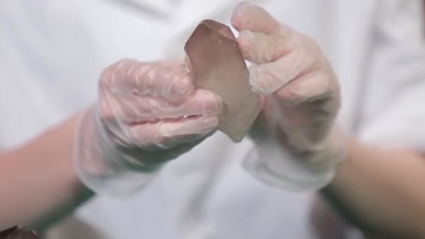Naturlig sten ametist eller annat mineral, sten. Vilda ametist i kvinnliga händer i vita handskar. Vaggar stenen i händer — Stockvideo