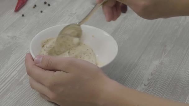 Mano masculina revolviendo la salsa con una cuchara. El hombre prepara una salsa de mayonesa para el plato — Vídeos de Stock