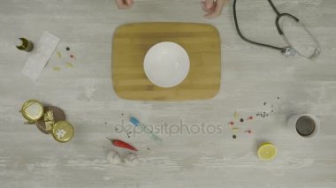 Süt kase veya plaka, dökme görünümü kapatın. Adam el ahşap stand üstten görünüm üzerinde bir kase içine dökme yoğunlaştırılmış süt