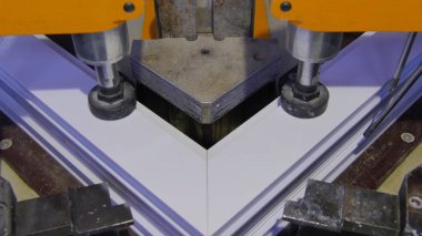 Kaynak Makinası fabrikasında çalışan işçi. PVC pencere Kaynak Makinası. Alüminyum pencere çerçeve basın makine. Çalışan bir pencere plastik üretir. Tehlike işareti ile endüstriyel basın yakın çekim.