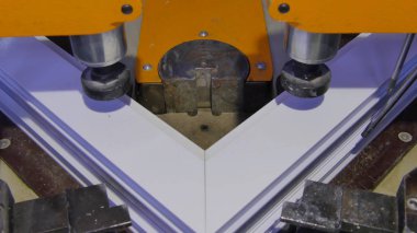 Kaynak Makinası fabrikasında çalışan işçi. PVC pencere Kaynak Makinası. Alüminyum pencere çerçeve basın makine. Çalışan bir pencere plastik üretir. Tehlike işareti ile endüstriyel basın yakın çekim.