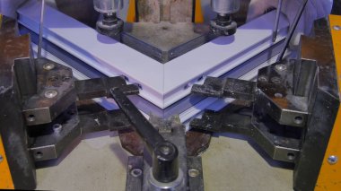 Kaynak Makinası fabrikasında çalışan işçi. PVC pencere Kaynak Makinası. Alüminyum pencere çerçeve basın makine. Çalışan bir pencere plastik üretir. Tehlike işareti ile endüstriyel basın yakın çekim.