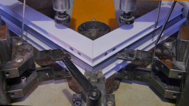 Kaynak Makinası fabrikasında çalışan işçi. PVC pencere Kaynak Makinası. Alüminyum pencere çerçeve basın makine. Çalışan bir pencere plastik üretir. Tehlike işareti ile endüstriyel basın yakın çekim.