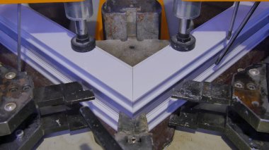 Kaynak Makinası fabrikasında çalışan işçi. PVC pencere Kaynak Makinası. Alüminyum pencere çerçeve basın makine. Çalışan bir pencere plastik üretir. Tehlike işareti ile endüstriyel basın yakın çekim.