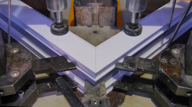 Kaynak Makinası fabrikasında çalışan işçi. PVC pencere Kaynak Makinası. Alüminyum pencere çerçeve basın makine. Çalışan bir pencere plastik üretir. Tehlike işareti ile endüstriyel basın yakın çekim.