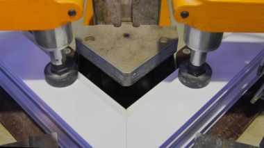 Kaynak Makinası fabrikasında çalışan işçi. PVC pencere Kaynak Makinası. Alüminyum pencere çerçeve basın makine. Çalışan bir pencere plastik üretir. Tehlike işareti ile endüstriyel basın yakın çekim.