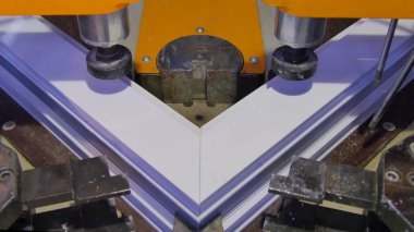 Kaynak Makinası fabrikasında çalışan işçi. PVC pencere Kaynak Makinası. Alüminyum pencere çerçeve basın makine. Çalışan bir pencere plastik üretir. Tehlike işareti ile endüstriyel basın yakın çekim.