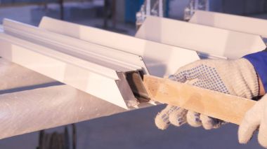 Pencere kapalı onarmak için silikon tüp kullanarak çalışan eller. Alüminyum pencere ayrıntılar. İnşaat işçisi pencere işyerinde yükleme. İhtiyar bir silikon tüp için kullanarak Backview