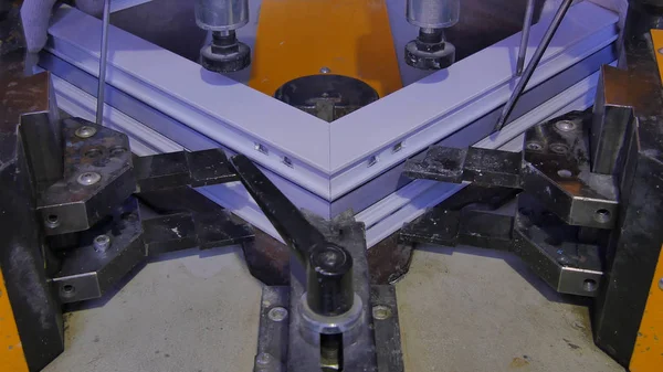 Kaynak Makinası fabrikasında çalışan işçi. PVC pencere Kaynak Makinası. Alüminyum pencere çerçeve basın makine. Çalışan bir pencere plastik üretir. Tehlike işareti ile endüstriyel basın yakın çekim.