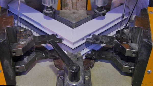 Kaynak Makinası fabrikasında çalışan işçi. PVC pencere Kaynak Makinası. Alüminyum pencere çerçeve basın makine. Çalışan bir pencere plastik üretir. Tehlike işareti ile endüstriyel basın yakın çekim.