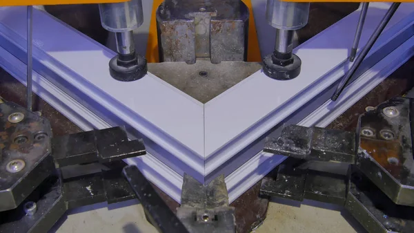 Kaynak Makinası fabrikasında çalışan işçi. PVC pencere Kaynak Makinası. Alüminyum pencere çerçeve basın makine. Çalışan bir pencere plastik üretir. Tehlike işareti ile endüstriyel basın yakın çekim.