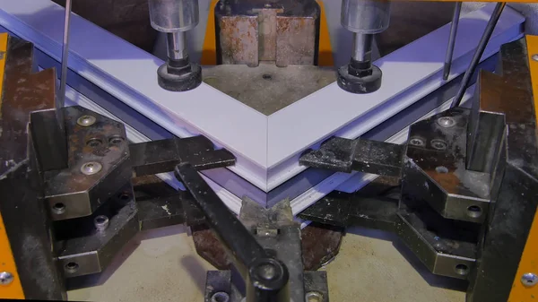 Kaynak Makinası fabrikasında çalışan işçi. PVC pencere Kaynak Makinası. Alüminyum pencere çerçeve basın makine. Çalışan bir pencere plastik üretir. Tehlike işareti ile endüstriyel basın yakın çekim.