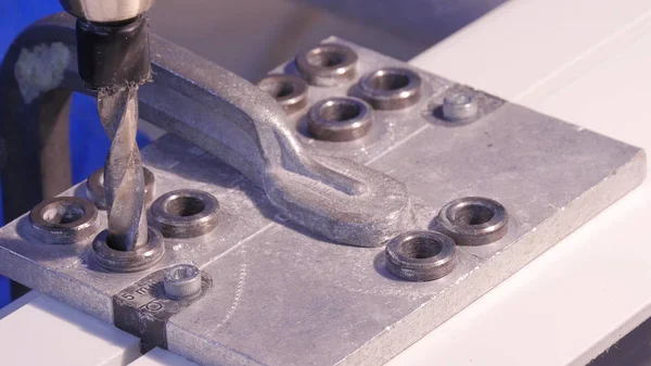Alüminyum ve metal elektrikli matkap kullanarak delinmiştir delik. Alüminyum veya metal metal atölyesinde closeup elektrikli matkapla Delme. Yassı çelik plaka Delme tezgah matkap ile çalışan.