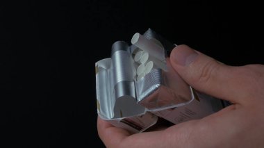 Kutusundan bir sigarette kadar çekerek el mans. Sigarette paketi closeup olsun. Bir adam bir çivi bir paket sigara dışarı çekerek closeup. Sigara kutusu. El bir sigara paketi dışarı alır.