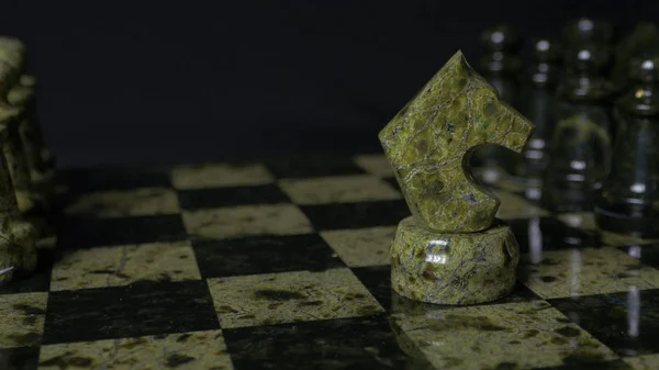 Ghess white horse defeats black pawn. Selective focus. Chess, Horse and pawn. Details of chess piece on black background. — Stock Photo, Image