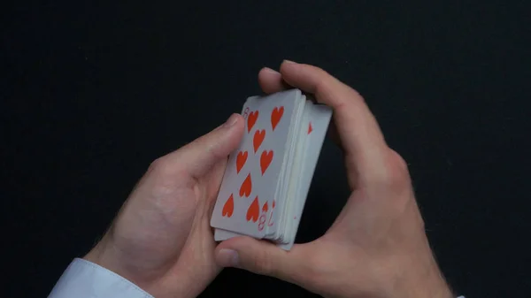 Juego de póquer - barajar cartas. Manos de hombre barajando cartas. De cerca. Manos de hombre barajando naipes. Distribuidores manos barajando cartas durante un juego de póquer — Foto de Stock