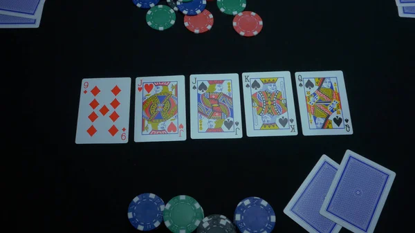 Detail of a royal flush on black background. Royal Flush of spade in poker game on a black background. Player collected The Royal Flush on a green poker table against black.