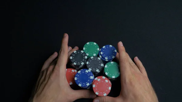 Stapel Pokerchips und zwei Hände auf dem Tisch. Nahaufnahme von Pokerchips in Stapeln auf einer grünen Filztischoberfläche. Pokerchips und Hände darüber am grünen Tisch. Händler — Stockfoto