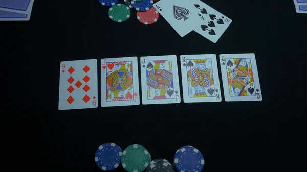 Detail of a royal flush on black background. Royal Flush of spade in poker game on a black background. Player collected The Royal Flush on a green poker table against black.