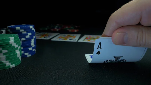 Persona mostrando su mazo en el juego de póquer. Jugador de cartas comprueba su mano, dos ases, fichas en el fondo en la mesa de juego verde, se centran en la tarjeta. Mano de dos ases en poker —  Fotos de Stock