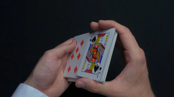 Poker game - shuffling cards. Mans hands shuffing cards. Close up. Mans hands shuffling playing cards. Dealers hands shuffling cards during a poker game