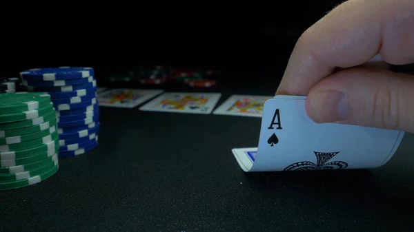 Persona che mostra il suo mazzo alla partita di poker. Giocatore di carte controlla la sua mano, due assi in, chip in background sul tavolo da gioco verde, concentrarsi sulla carta. Mano di due assi nel poker — Foto Stock