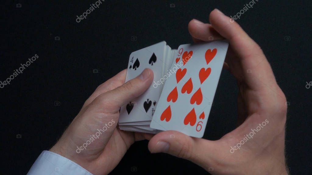 Poker game - shuffling cards. Mans hands shuffing cards. Close up. Mans hands shuffling playing cards. Dealers hands shuffling cards during a poker game 4K