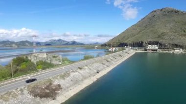 Köprü mavi deniz, dağlar ve gökyüzü arka plan üzerinde siyah araba. Görüntüleri. Araba hava görünümünü Nehri yakınında bir yolda gidiyor. Görüntüleri. Küçük orman Gölü ve otoyol yakınında geçen bir çizgi, havadan görünümü
