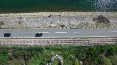 Araba hava görünümünü Nehri yakınında bir yolda gidiyor. Görüntüleri. Küçük orman Gölü ve otoyol yakınında geçen bir çizgi, havadan görünümü. Araba hava görünümünü Nehri yakınında bir yolda gidiyor. Görüntüleri. Havadan görünümü