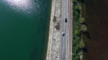 Yakın hareket ile araba araba gösteren bir Otoban yol Gölü üzerinde hızlı hareket bulanıklığı. Görüntüleri. Yol yolculuk seyahat, araba kiralama ve Turizm kavramı. Denize yakın dağlarda mavi gökyüzü ile yola