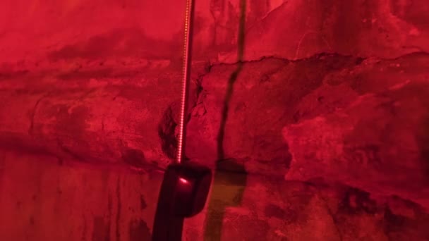 Handset telepon di jalan kota malam. Footage. Sebuah bilik telepon koin kuno di sudut dengan lampu merah menyeramkan — Stok Video