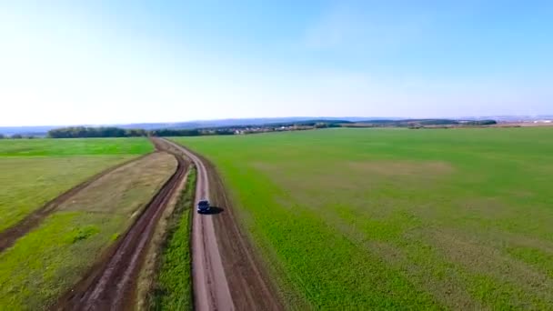 El coche en la naturaleza. Fotage. Coche negro conduciendo por carretera rural. Antena — Vídeo de stock