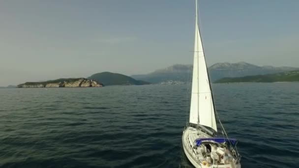 Widok z nad żaglówkę w wodzie raj. Materiał filmowy. Biały jacht na morzu — Wideo stockowe