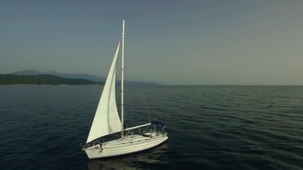 Vista dall'alto di una barca a vela in un paradiso acquatico. Un filmato. Barca a vela bianca in mare — Video Stock