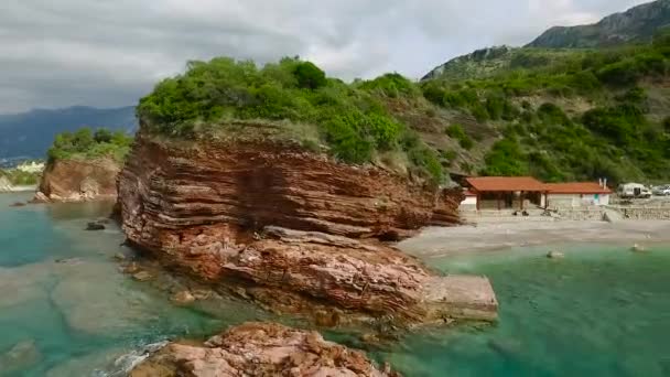 Rotsachtige kust In de zee met bos. Beeldmateriaal. Luchtfoto — Stockvideo