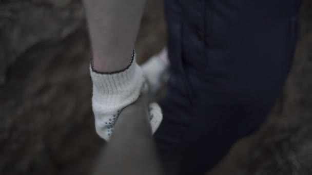 Het graven van een loopgraaf. Beeldmateriaal. Handen werden graven met schoppen. Mannenhand graven met een schop. De aarde in de schop close-up — Stockvideo