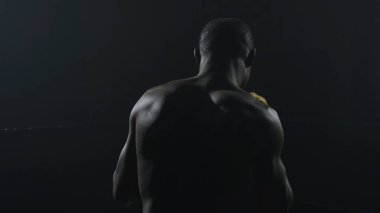 Kaslı adam siyah arka plan üzerine boks dikiz. Afro Amerikan genç erkek boxer gölge boks pratik