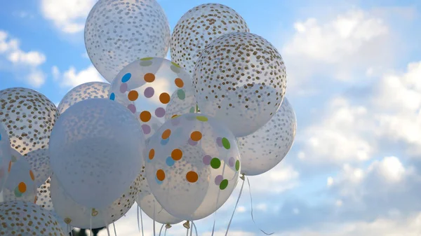 White balloons against the sky. White balls in the sky