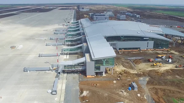 The construction of the airport with runway. Aerial view of Airport runway become a construction site. workers build the new airport and special equipment. Airport construction and Sky with Clouds