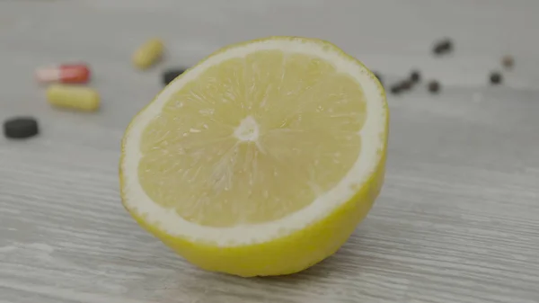 Половина стиглого жовтого лимона на столі. Один нарізаний лимон на столі — стокове фото