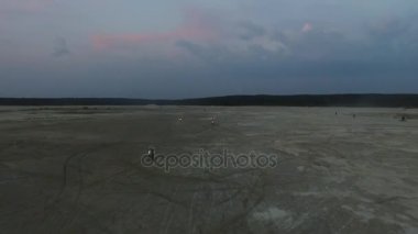 Motocross yarışçılar başına motosiklet büyük tüy kum kumlu parapet parça boyunca hareket eder. Görüntüleri. Motosikletçiler kumlu yollarda bitirmek karar vermiş. Ani sandy motosikletçiler manevralar açmak