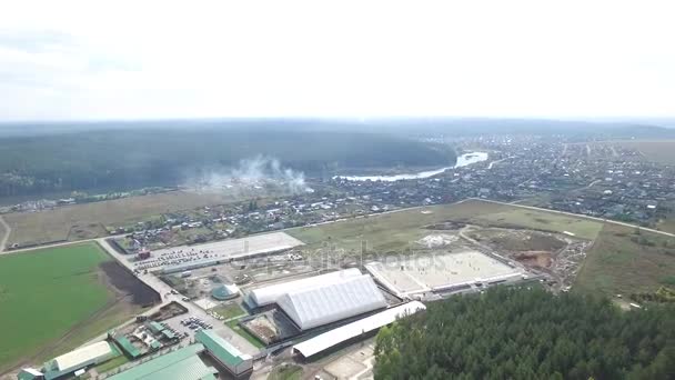 Вид с воздуха на маленький городок. Запись. Маленькая деревня. Поле и лес на переднем плане. Прекрасный летний пейзаж — стоковое видео