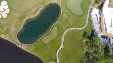 Güneşli bir golf sahası, gölet ve yeşil çimen, mükemmel bir Golf sopasıyla görüntülemek gökten