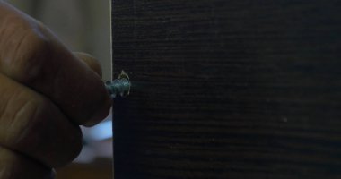 Bir elektrikli el matkabı bir Pano bir vida sürücü kullanan adam. Ortamda bulunan toz tanecikleri Parlatıcı havadaki toz. Vida sıkma