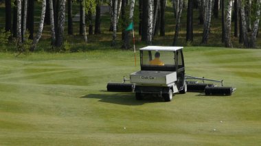 İskoç bir golf sahasının kenarında çim biçme makinesi iş. Makine için çim üzerinde Golf