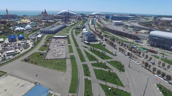 A pista de fórmula 1 em Sochi, a vila olímpica de Sochi. Local de construção do estádio para corridas perto da cidade e montanhas no dia ensolarado de verão. Vista aérea. Vista aérea sobre peitoril stands F1 russo — Fotografia de Stock