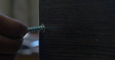 Bir elektrikli el matkabı bir Pano bir vida sürücü kullanan adam. Ortamda bulunan toz tanecikleri Parlatıcı havadaki toz. Vida sıkma