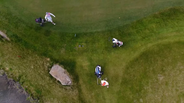 Vista aerea Campo da golf. Golfisti che camminano lungo il fairway su un campo da golf con borsa e carrello — Foto Stock